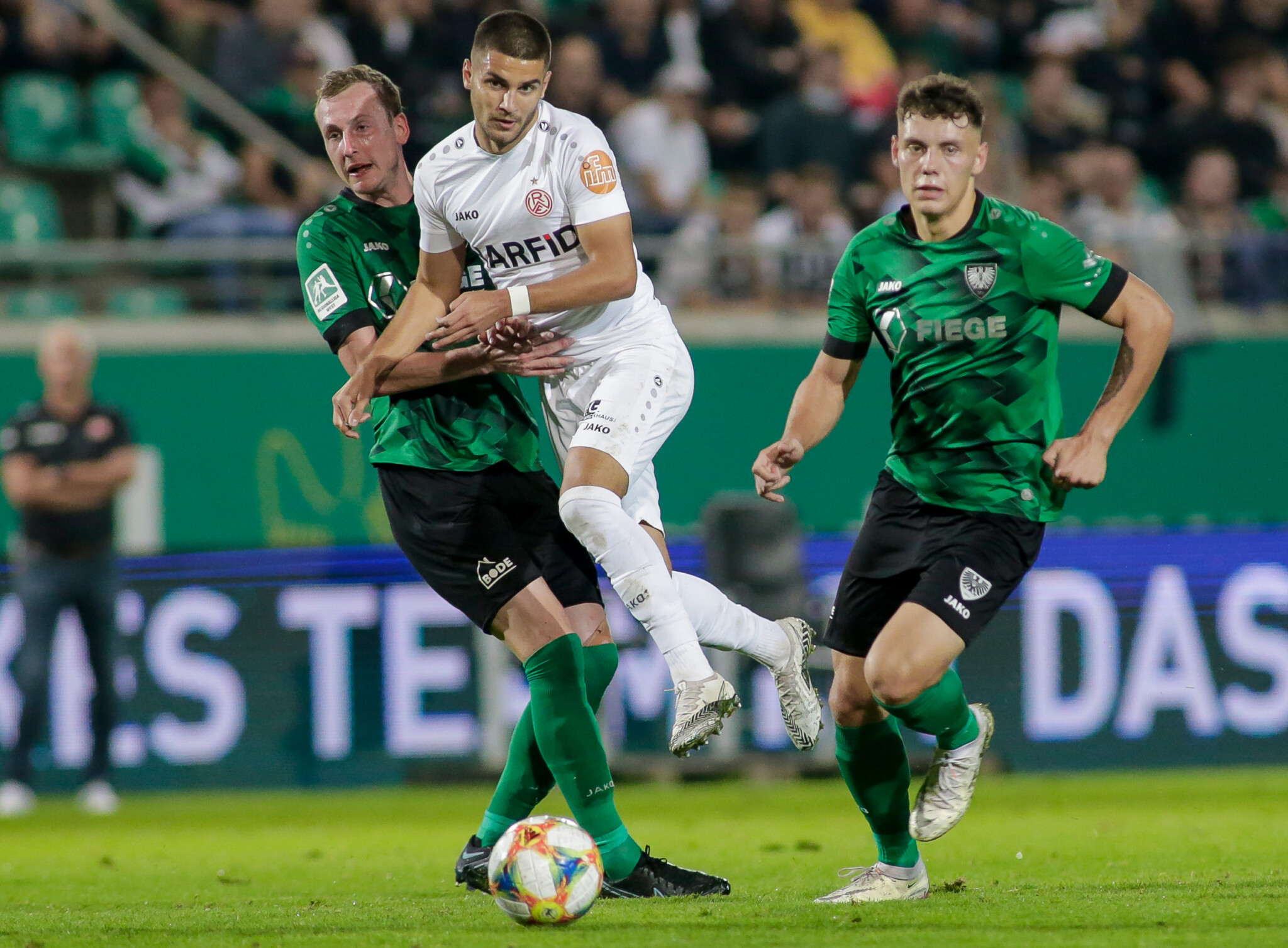 Erolind Krasniqi kämpft mit zwei Preußen-Münster-Spielern um den Ball.