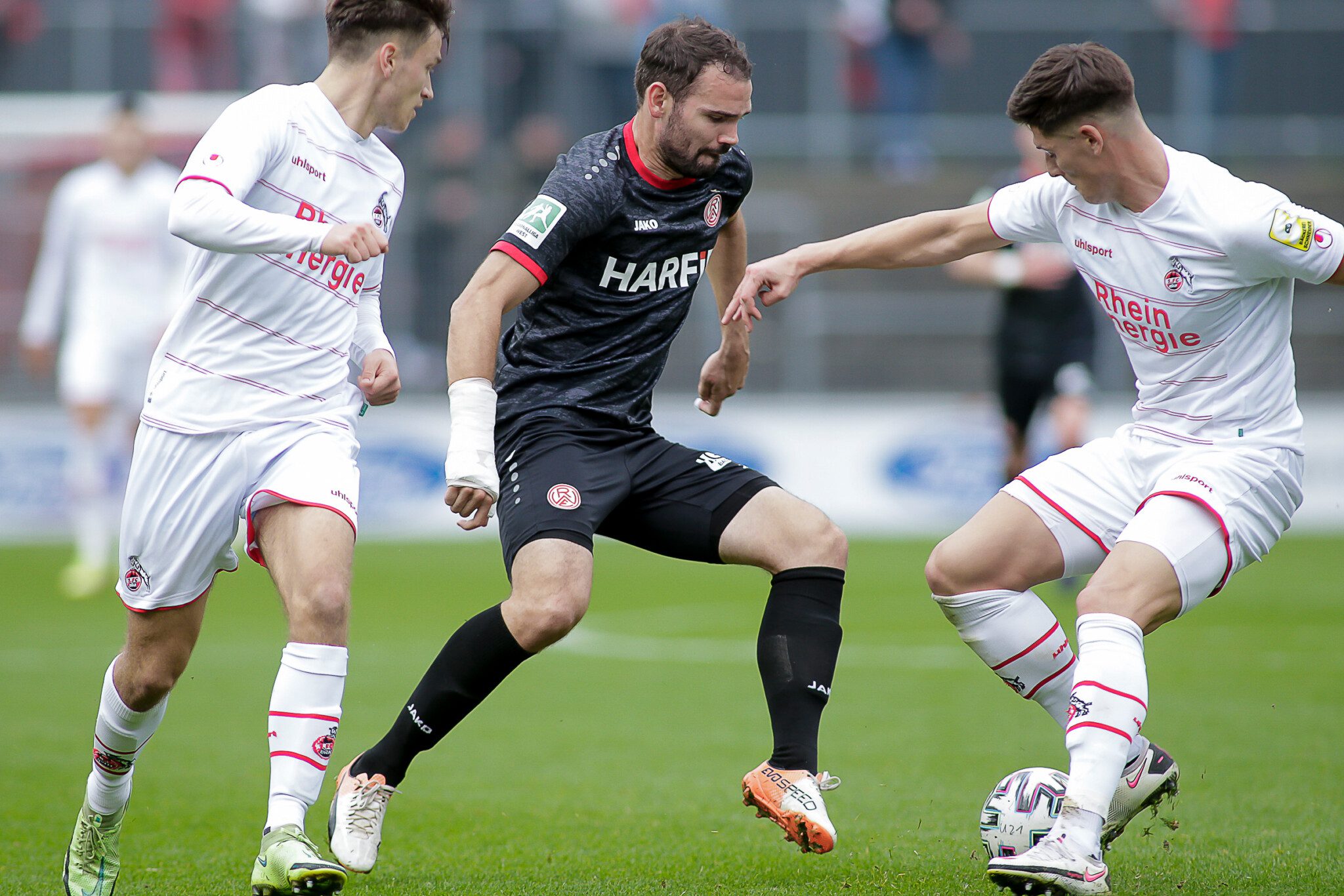 Simon Engelmann gegen zwei Gegenspieler vom 1. FC Köln.