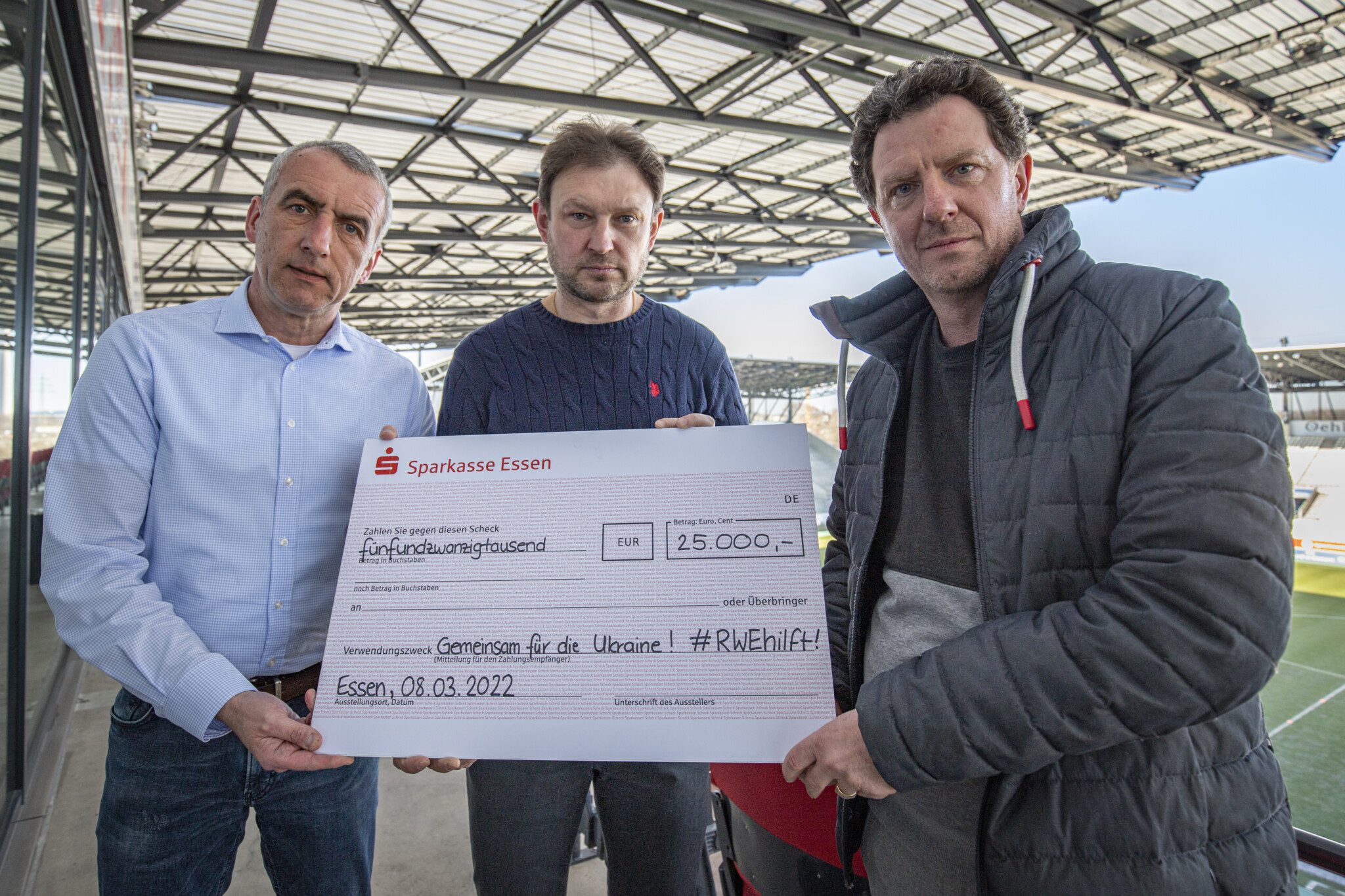 Marcus Uhlig, Igor Denysiuk und Tani Capitain mit dem Spendenscheck für schnelle Ukraine-Hilfe.