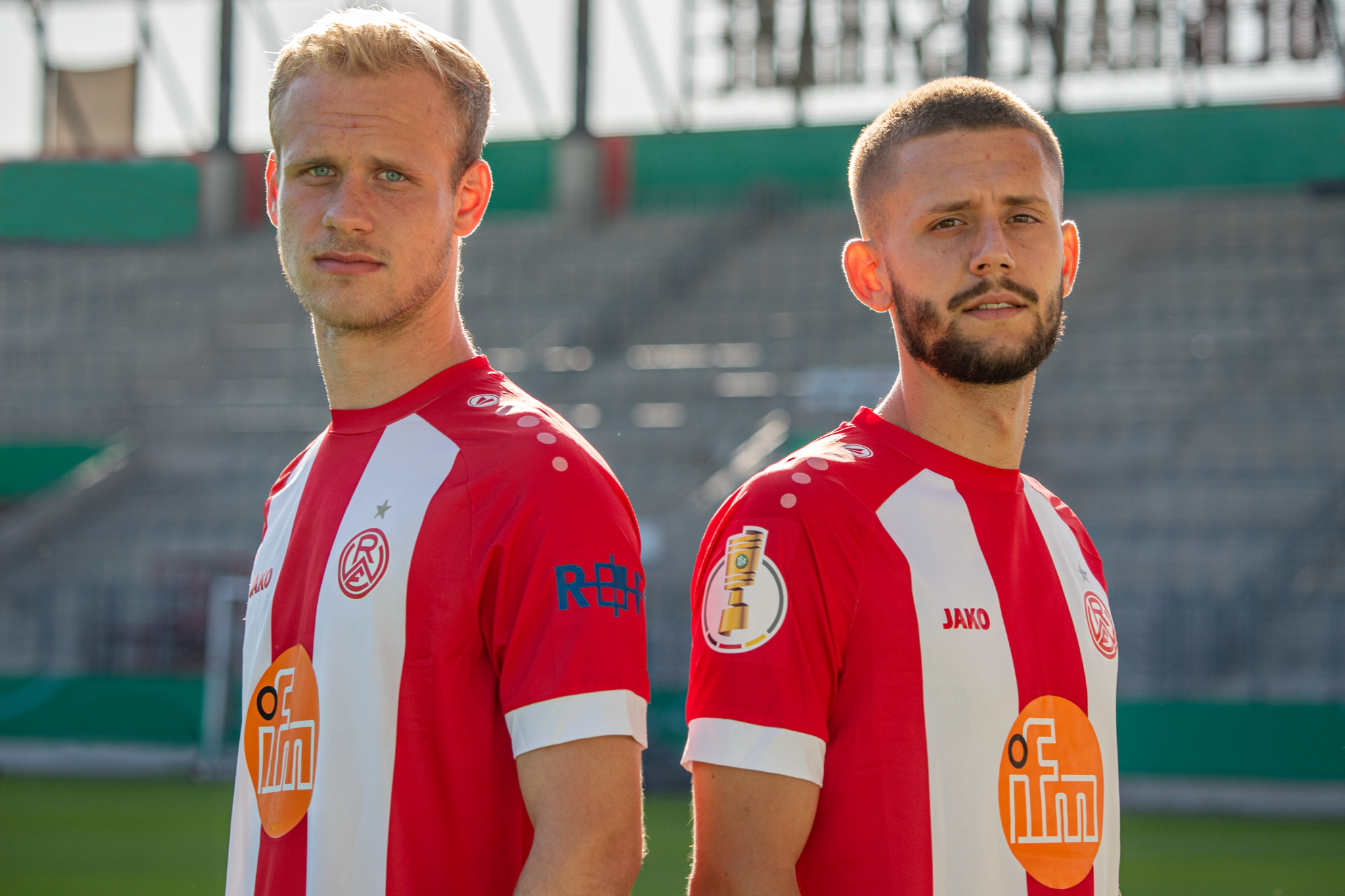 Die RWE-Spieler Lucas Brumme (l.) und Torben Müsel präsentieren das DFB-Pokaltrikot.